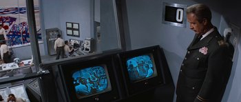 Movie still from “Fantastic Voyage” (1966), directed by Richard Fleischer – A couple of tvs in front of a mirror; Medium shot, Over the shoulder angle