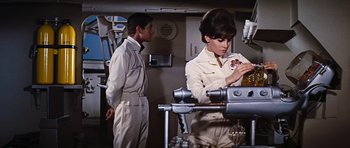 Movie still from “Fantastic Voyage” (1966), directed by Richard Fleischer – A man and a woman are standing next to each other in a room; Medium shot, High angle