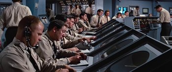 Movie still from “Fantastic Voyage” (1966), directed by Richard Fleischer – A group of men sitting in front of computer monitors; Medium shot, Low angle