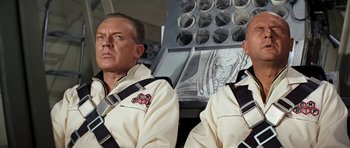 Movie still from “Fantastic Voyage” (1966), directed by Richard Fleischer – Two men are sitting next to each other; Medium shot, Low angle