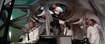Movie still from “Fantastic Voyage” (1966), directed by Richard Fleischer – Two men sitting on a boat in the water; Wide shot, Low angle
