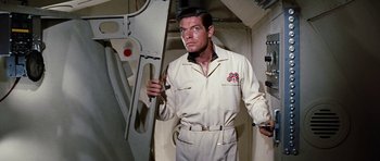 Movie still from “Fantastic Voyage” (1966), directed by Richard Fleischer – A man in a white suit holding a wrench; Medium shot, Low angle