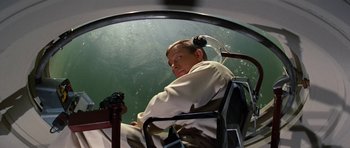 Movie still from “Fantastic Voyage” (1966), directed by Richard Fleischer – A man sitting in a chair in front of a fish tank; Medium shot, High angle