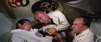 Movie still from “Fantastic Voyage” (1966), directed by Richard Fleischer – A man in a white shirt is fighting with another man in a white shirt; Medium shot, High angle