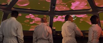 Movie still from “Fantastic Voyage” (1966), directed by Richard Fleischer – Two men in white lab coats looking out a window; Medium shot, Low angle