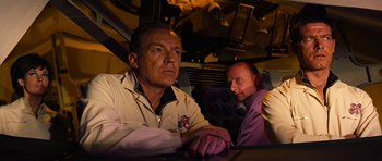 Movie still from “Fantastic Voyage” (1966), directed by Richard Fleischer – Two men sitting at a table in front of an airplane; Medium shot, Low angle