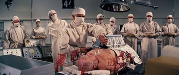 Movie still from “Fantastic Voyage” (1966), directed by Richard Fleischer – A group of surgeons performing surgery on a man's face; Medium shot, High angle