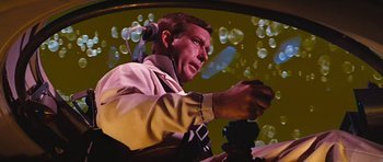Movie still from “Fantastic Voyage” (1966), directed by Richard Fleischer – A man is holding a remote control in his hand; Close Up shot, Low angle