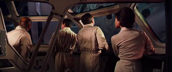Movie still from “Fantastic Voyage” (1966), directed by Richard Fleischer – A group of people standing next to each other in a room; Medium shot, Low angle