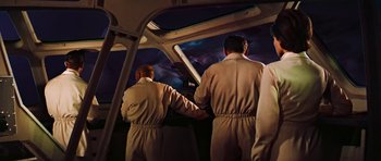 Movie still from “Fantastic Voyage” (1966), directed by Richard Fleischer – Two men in white suits standing next to each other in front of a window; Medium shot, Low angle