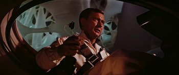 Movie still from “Fantastic Voyage” (1966), directed by Richard Fleischer – A man holding a cell phone up to his ear; Medium shot, Low angle
