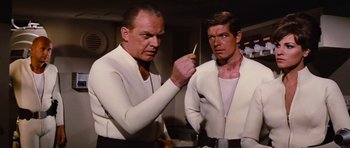Movie still from “Fantastic Voyage” (1966), directed by Richard Fleischer – Two men in white shirts and white jackets are looking at each other in a room; Medium shot, Over the shoulder angle