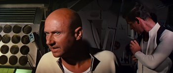 Movie still from “Fantastic Voyage” (1966), directed by Richard Fleischer – A man with a bald head is looking into the distance; Close Up shot, Over the shoulder angle