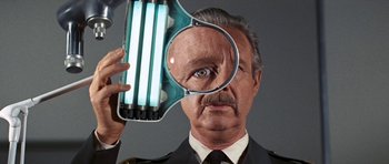 Movie still from “Fantastic Voyage” (1966), directed by Richard Fleischer – An older man holding a magnifying glass over his face; Extreme Close Up shot, Low angle