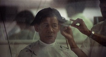 Movie still from “Fat City” (1972), directed by John Huston – A man getting his hair cut at a barber shop; Close Up shot, Over the shoulder angle
