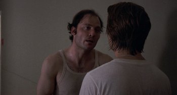 Movie still from “Fat City” (1972), directed by John Huston – A man looking at himself in the mirror in front of a mirror; Close Up shot, Over the shoulder angle