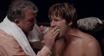 Movie still from “Fat City” (1972), directed by John Huston – A man is brushing his teeth while another man watches; Close Up shot, Low angle