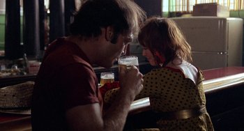 Movie still from “Fat City” (1972), directed by John Huston – A man and a woman sitting at a table with a glass of beer; Medium shot, Over the shoulder angle