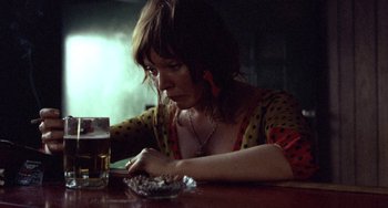 Movie still from “Fat City” (1972), directed by John Huston – A woman sitting at a table looking at a piece of cake; Close Up shot, Low angle