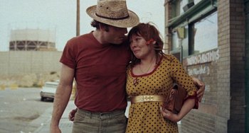 Movie still from “Fat City” (1972), directed by John Huston – A man and a woman standing next to each other on the street; Medium shot, Low angle