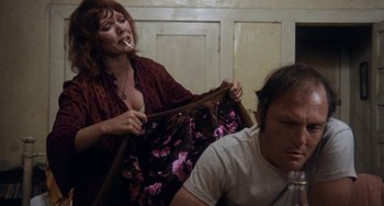 Movie still from “Fat City” (1972), directed by John Huston – A woman holding a bag while sitting next to a man; Medium shot, Low angle