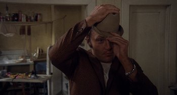 Movie still from “Fat City” (1972), directed by John Huston – A man holding a hat up to his face; Close Up shot, Low angle