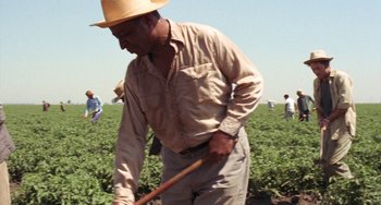 Movie still from “Fat City” (1972), directed by John Huston – An old man wearing a straw hat and holding a wooden stick; Medium shot, Low angle