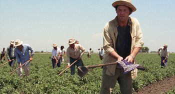 Movie still from “Fat City” (1972), directed by John Huston – A group of people in a field with a shovel; Medium shot, High angle