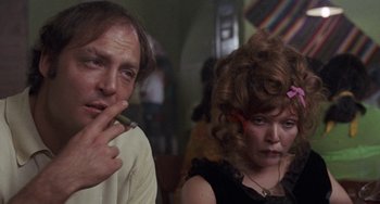 Movie still from “Fat City” (1972), directed by John Huston – A man and a woman are smoking a cigarette together; Close Up shot, Low angle