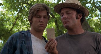 Movie still from “Fat City” (1972), directed by John Huston – Two men looking at a piece of paper in front of trees; Close Up shot, Low angle