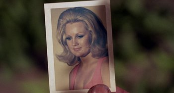 Movie still from “Fat City” (1972), directed by John Huston – An old photo of a woman in a pink dress; Extreme Close Up shot, High angle