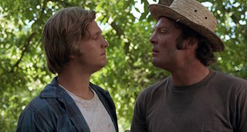 Movie still from “Fat City” (1972), directed by John Huston – Two men standing next to each other in front of a tree; Close Up shot, Over the shoulder angle