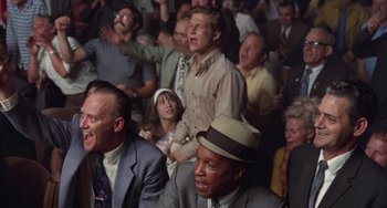 Movie still from “Fat City” (1972), directed by John Huston – A group of people sitting in a room; Medium shot, High angle