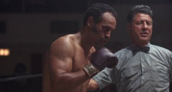 Movie still from “Fat City” (1972), directed by John Huston – A man in a boxing ring wearing a purple glove; Medium shot, Low angle