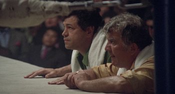 Movie still from “Fat City” (1972), directed by John Huston – A couple of men sitting next to each other at a table; Medium shot, Low angle