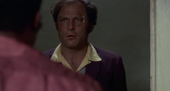 Movie still from “Fat City” (1972), directed by John Huston – A man in a suit looking at a mirror; Close Up shot, Over the shoulder angle