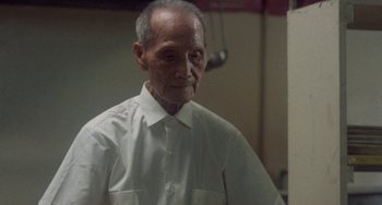 Movie still from “Fat City” (1972), directed by John Huston – An older man wearing a white shirt looking at the camera; Medium shot, Low angle