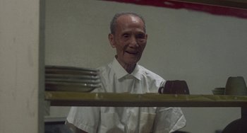 Movie still from “Fat City” (1972), directed by John Huston – An older man standing in front of a stack of forks; Close Up shot, Low angle
