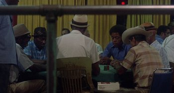 Movie still from “Fat City” (1972), directed by John Huston – A group of men sitting around a table playing cards; Medium shot, High angle