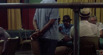 Movie still from “Fat City” (1972), directed by John Huston – A group of men sitting around a room; Medium shot, Over the shoulder angle