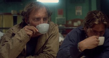 Movie still from “Fat City” (1972), directed by John Huston – A man and a woman sitting at a table drinking coffee; Medium shot, Low angle