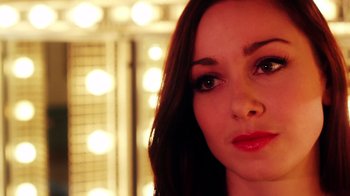 Movie still from “Father's Day” (2011), directed by Conor Sweeney – A woman's face in front of lights; Close Up shot, Over the shoulder angle