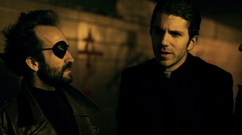 Movie still from “Father's Day” (2011), directed by Conor Sweeney – A man in a priest's outfit talking to another man in a priest's outfit; Close Up shot, Over the shoulder angle