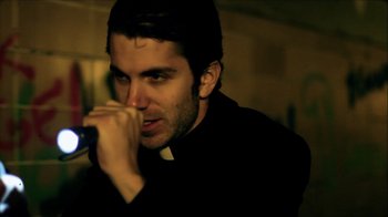 Movie still from “Father's Day” (2011), directed by Conor Sweeney – A person singing into a microphone; Close Up shot, Low angle