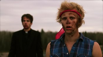 Movie still from “Father's Day” (2011), directed by Conor Sweeney – Two people dressed up as zombies in a field; Medium shot, Over the shoulder angle
