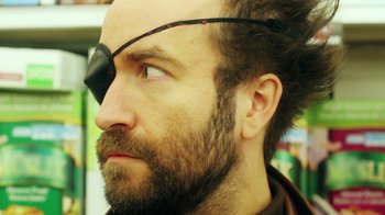 Movie still from “Father's Day” (2011), directed by Conor Sweeney – A man with a beard wearing a pirate eye patch; Extreme Close Up shot, Low angle