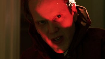 Movie still from “Father's Day” (2011), directed by Conor Sweeney – A person's face in a red light; Close Up shot, Low angle