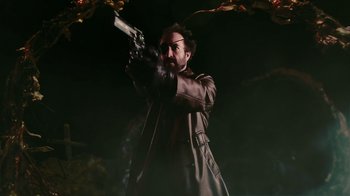 Movie still from “Father's Day” (2011), directed by Conor Sweeney – A man in a trench coat holding a gun in the dark; Medium shot, Low angle
