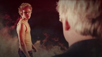 Movie still from “Father's Day” (2011), directed by Conor Sweeney – A young boy is standing in front of a fire; Medium shot, Over the shoulder angle