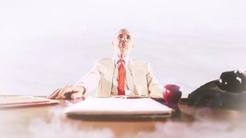 Movie still from “Father's Day” (2011), directed by Conor Sweeney – A man sitting at a table with an apple; Medium shot, Low angle